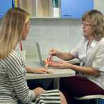 Gynecologist holding female uterus anatomy model and explains Tubal Ligation to patient