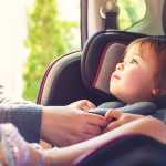Toddler girl in her car seat looking at her mothers