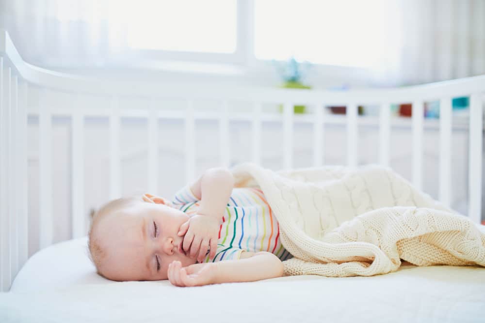 Baby rolling on side in bassinet