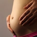 Belly of a pregnant woman with first signs of labor