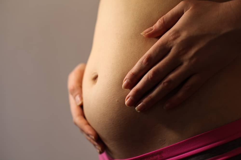 Belly of a pregnant woman with first signs of labor