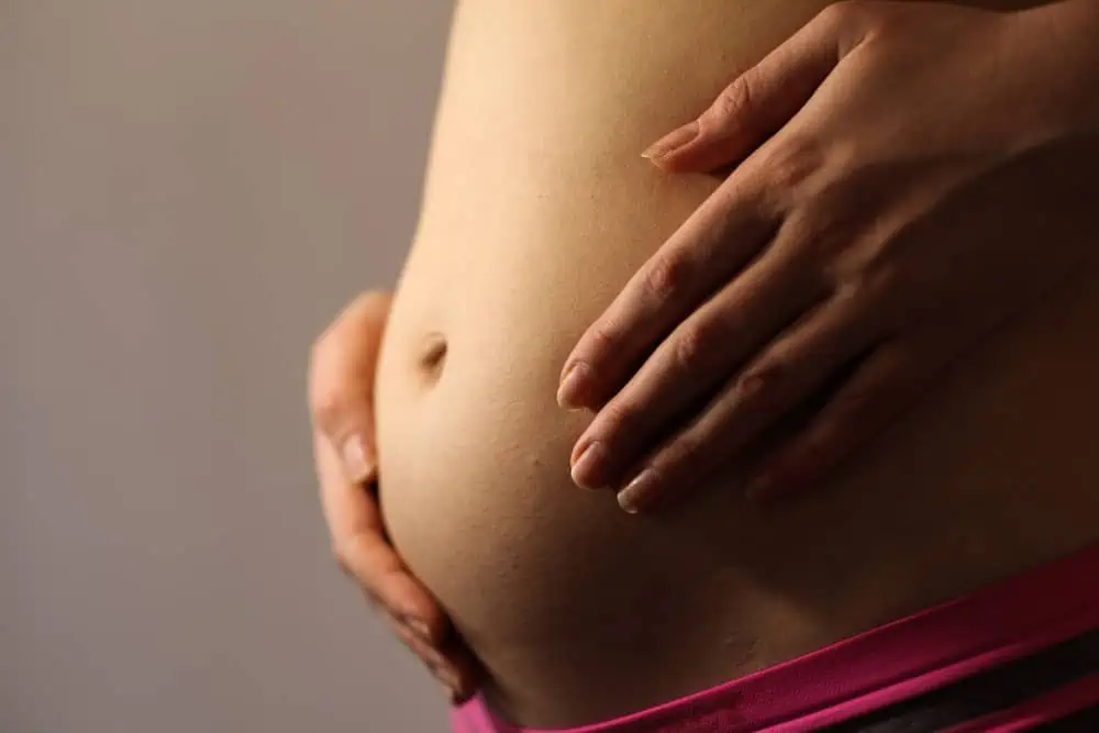 Belly of a pregnant woman with first signs of labor