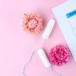 menstrual cycle. Tampons, women's calendar, flowers on a pink background
