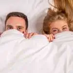 Young lovely couple lying in a bed,