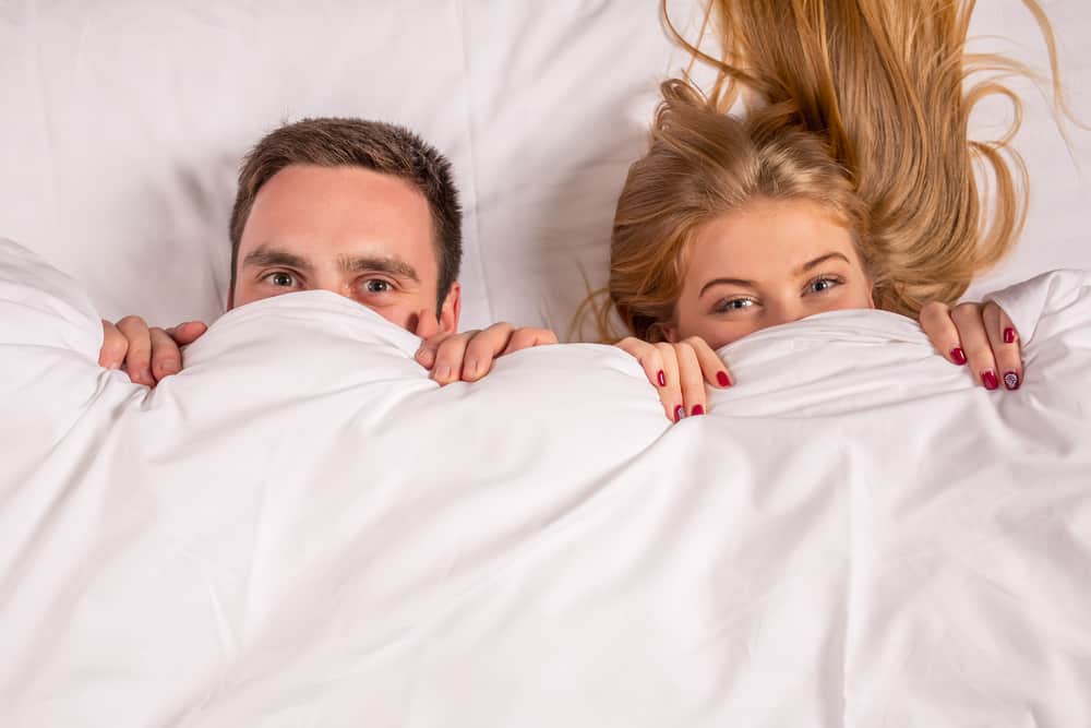 Young lovely couple lying in a bed,