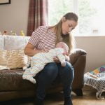 Mother Burping Her Baby on her knees