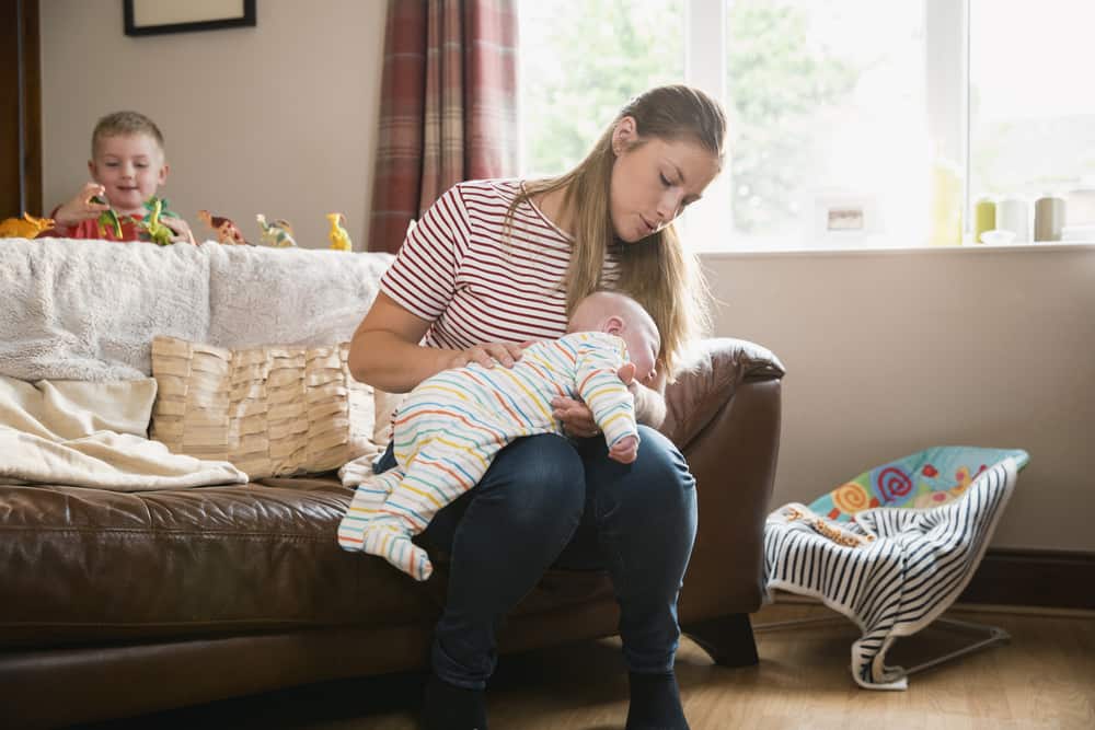 Mother Burping Her Baby on her knees