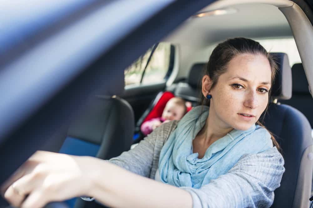 A Mother driving with Baby in the back