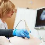 Ultrasound test. Pregnancy. Gynecologist checking fetal life with scanner.