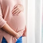 pregnant woman touches belly
