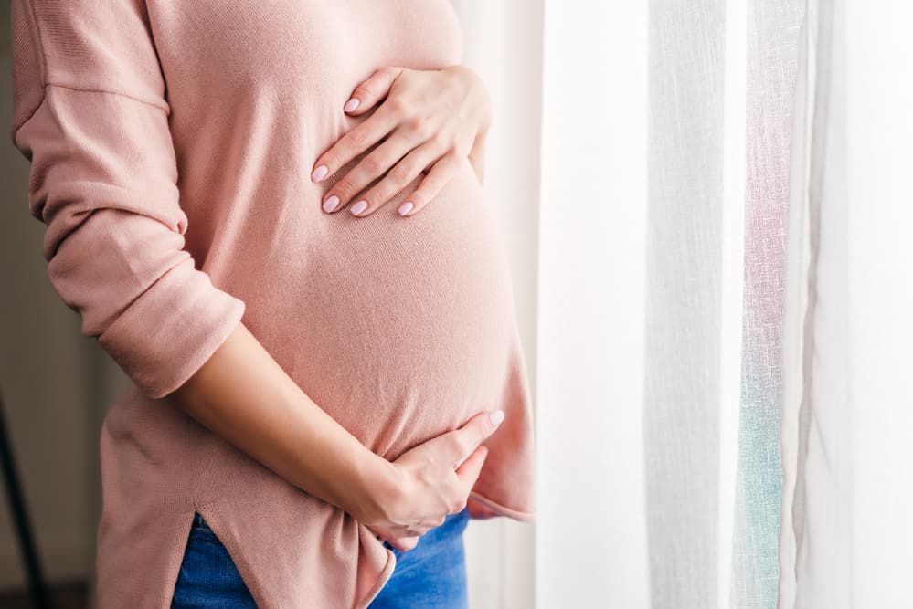 pregnant woman touches belly