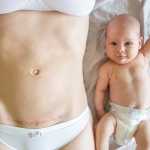 Closeup of woman belly with a scar from a cesarean section and her baby near
