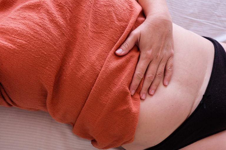 Woman after Cesarean checks belly