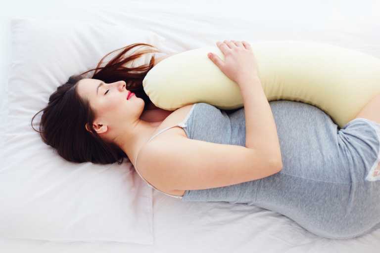 woman sleeps on side with pillow